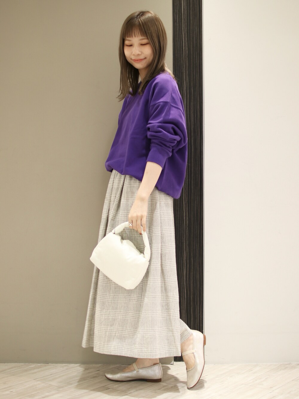 ホワイト系のスカート、パープル系のスウェット、ゴールド系のその他シューズを着用したレディースの秋コーディネートの3枚目の写真