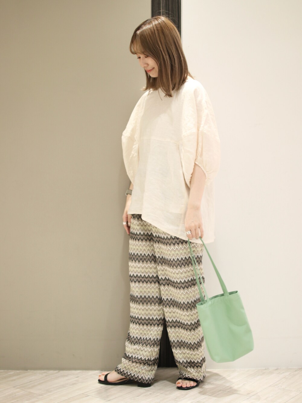 ベージュ系のシャツ/ブラウス、グリーン系のトートバッグ、ベージュ系のその他パンツを着用したレディースの春コーディネートの4枚目の写真