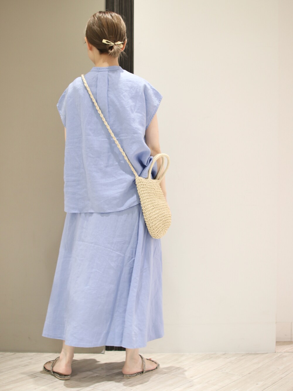 グレー系のサンダル、ブルー系のスカート、ベージュ系のショルダーバッグを着用したレディースの夏コーディネートの3枚目の写真