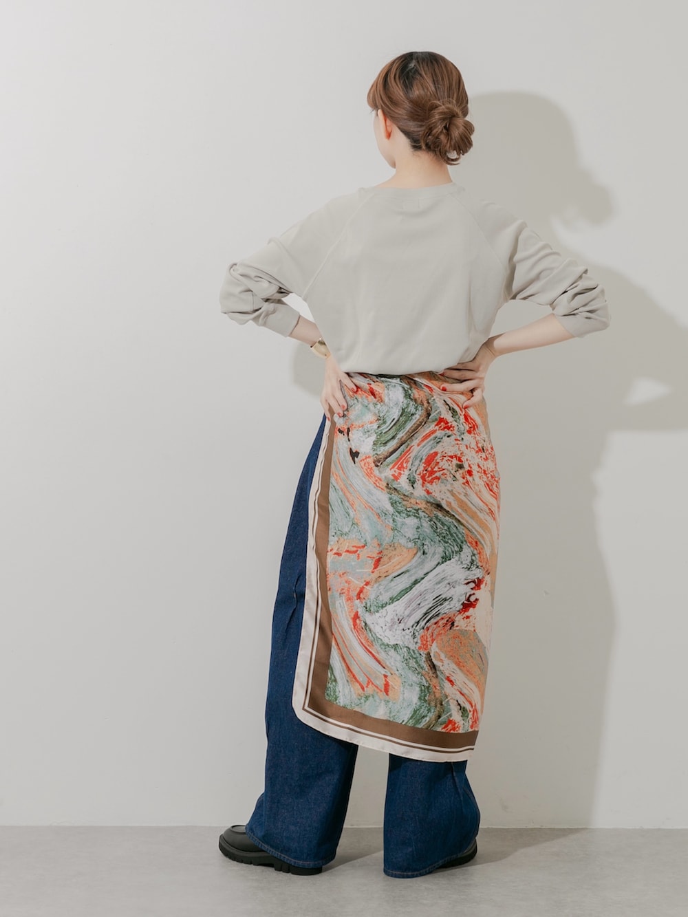 ブラック系のローファー、ベージュ系のTシャツ/カットソー、ブルー系のデニムパンツを着用したレディースの秋コーディネートの5枚目の写真