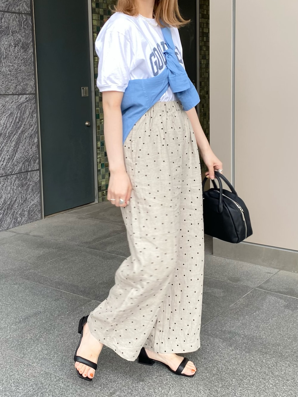 ブラック系のサンダル、ブラック系のボストンバッグ、ベージュ系のその他パンツを着用したレディースの夏コーディネートの4枚目の写真