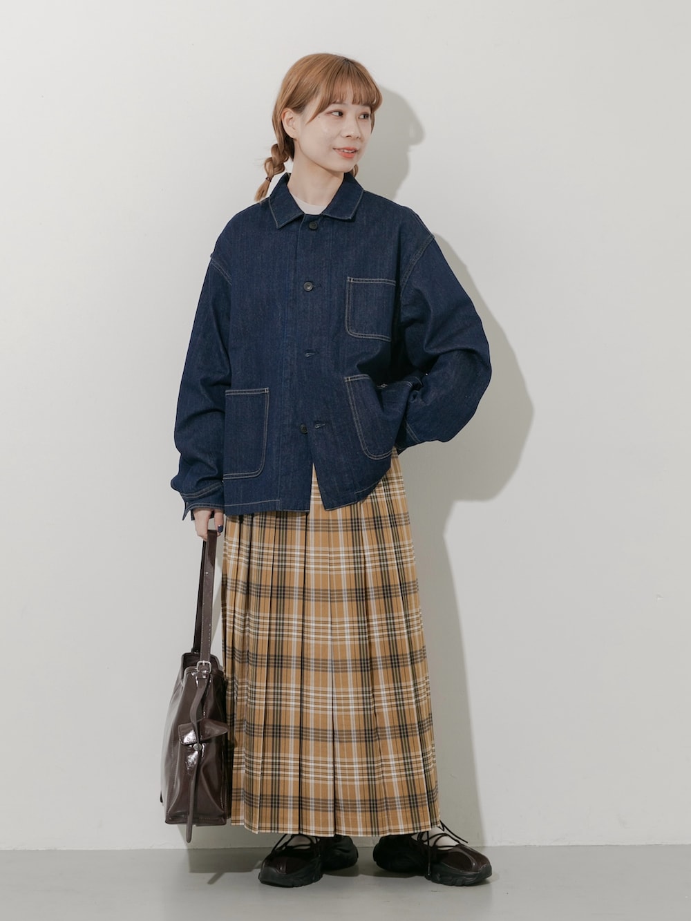 ブラウン系のスニーカー、ブルー系のカバーオール、イエロー系のスカートを着用したレディースの秋コーディネートの5枚目の写真