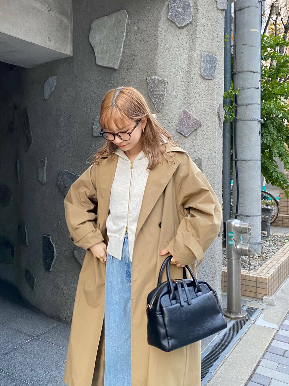 ブラック系のボストンバッグ、ブラック系のブーツ、ベージュ系のパーカーを着用したレディースの冬コーディネートの5枚目の写真