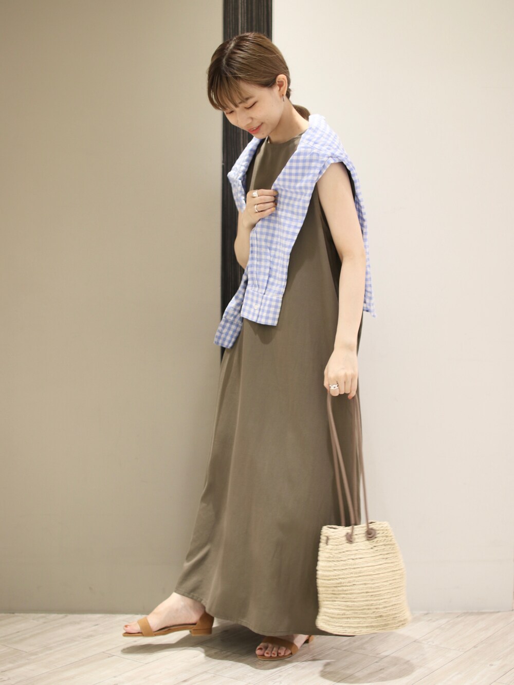 グリーン系のワンピース、ブルー系のシャツ/ブラウス、ベージュ系のショルダーバッグを着用したレディースの夏コーディネートの3枚目の写真