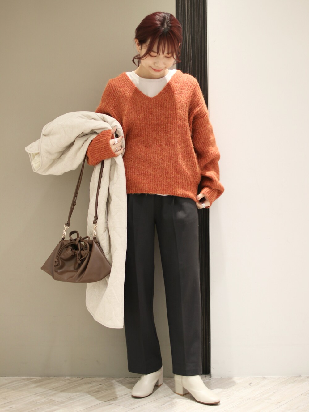 グレー系のその他パンツ、ブラウン系のハンドバッグ、ホワイト系のブーツを着用したレディースの冬コーディネートの2枚目の写真