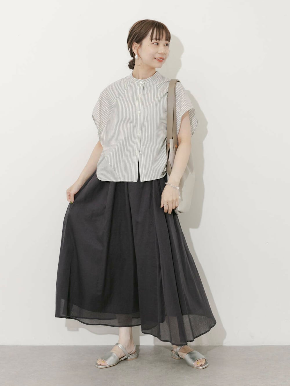グレー系のスカート、ホワイト系のシャツ/ブラウス、シルバー系のサンダルを着用したレディースの夏コーディネートの8枚目の写真