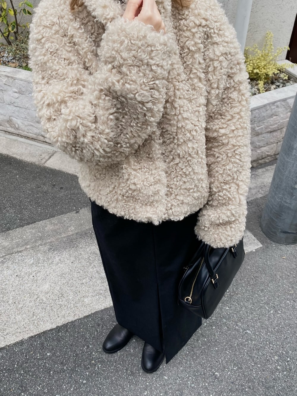 ホワイト系のその他アウター、ブラック系のスカート、ブラック系のボストンバッグを着用したレディースの冬コーディネートの3枚目の写真