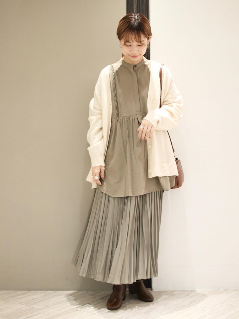 ホワイト系のカーディガン/ボレロ、グレー系のシャツ/ブラウス、ブラウン系のショルダーバッグを着用したレディースの秋コーディネートの2枚目の写真