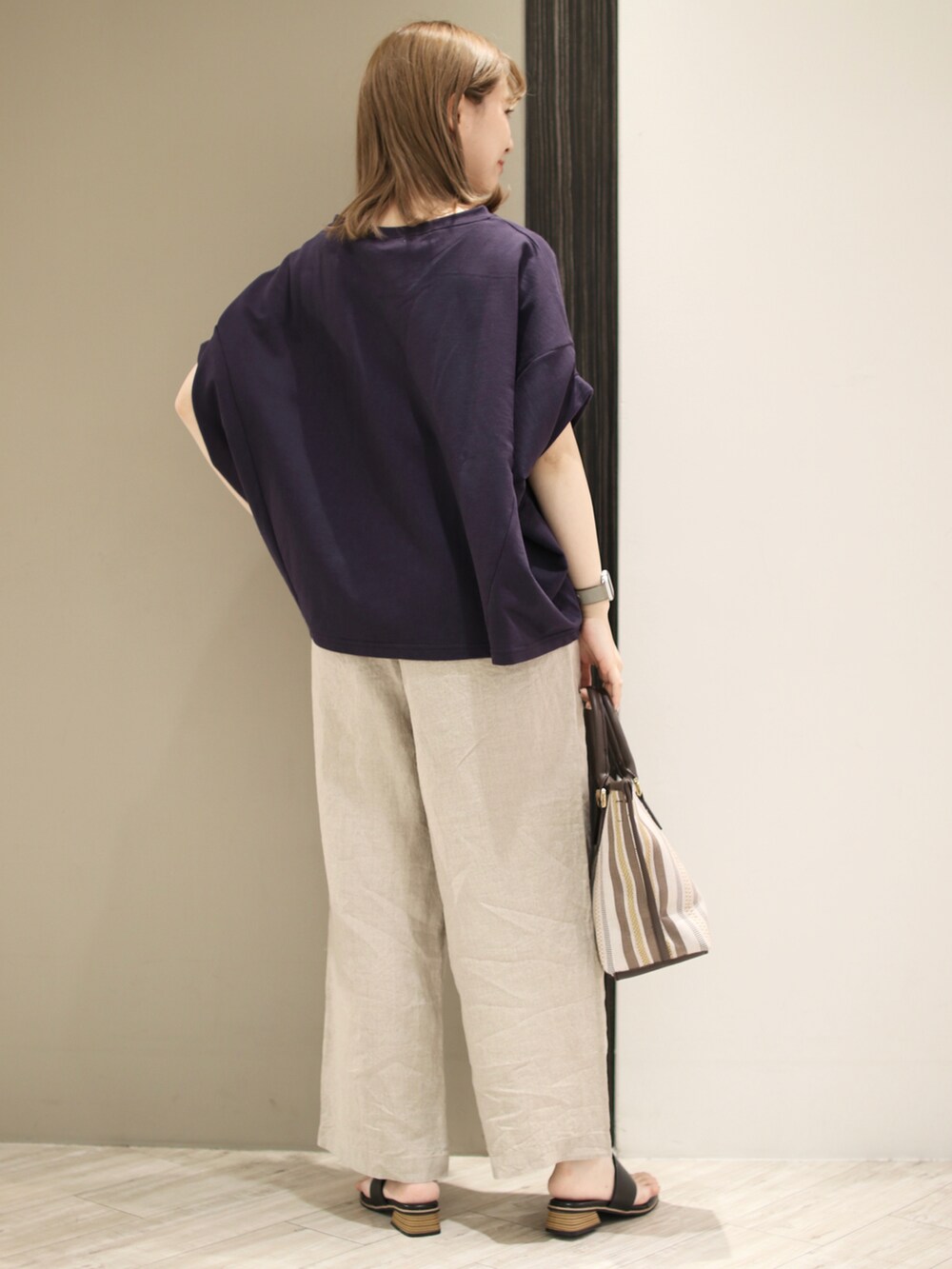 ブラウン系のトートバッグ、ベージュ系のその他パンツ、ブラック系のサンダルを着用したレディースの春コーディネートの4枚目の写真