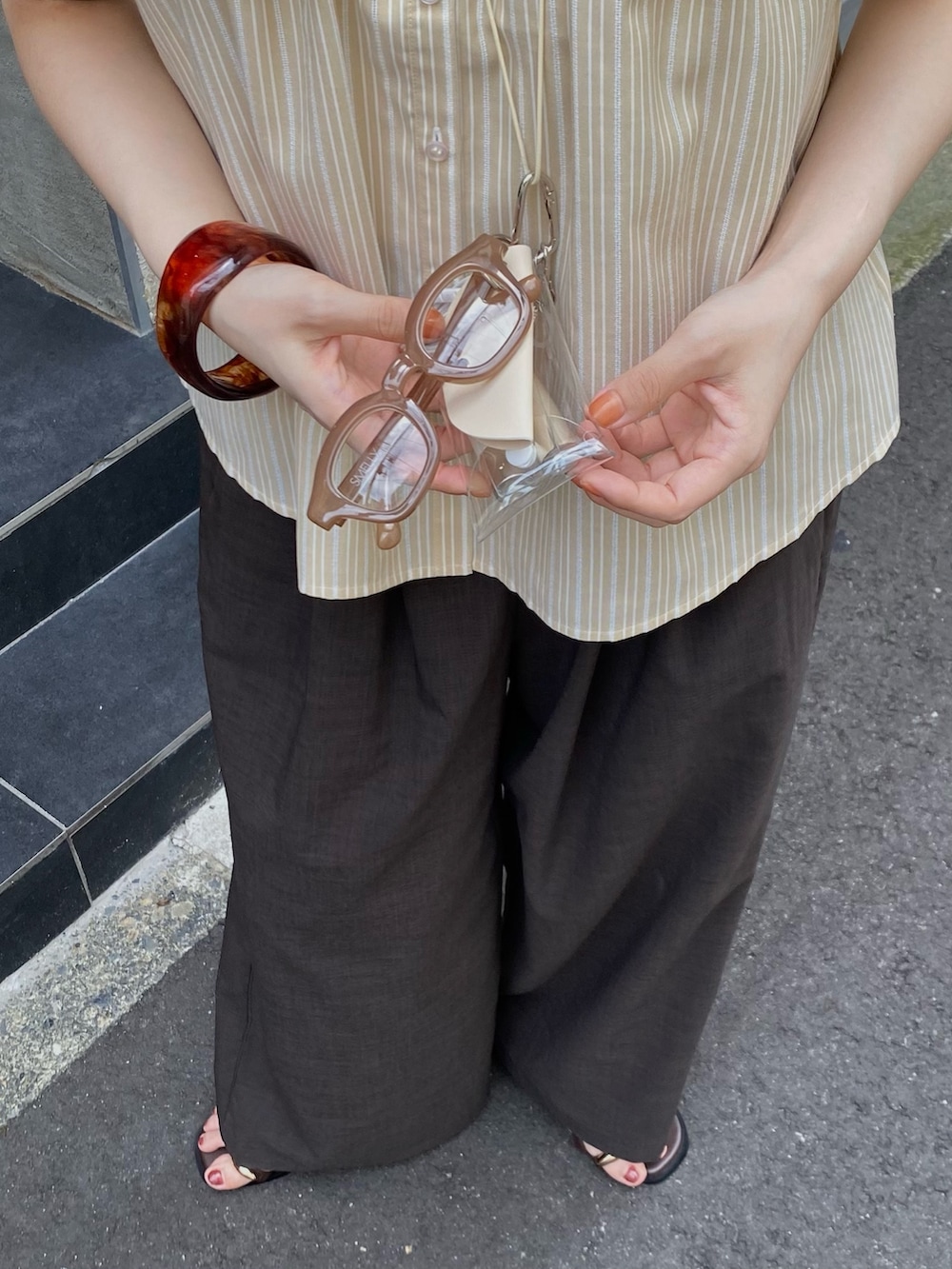 ベージュ系のシャツ/ブラウス、グレー系のその他パンツ、ブラウン系のサンダルを着用したレディースの夏コーディネートの4枚目の写真