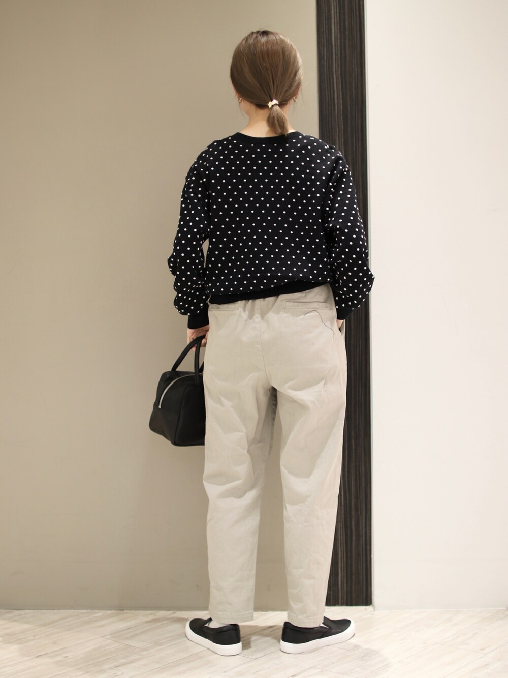 ベージュ系のその他パンツ、ブラック系のカーディガン/ボレロ、ブラック系のトートバッグを着用したレディースの冬コーディネートの4枚目の写真