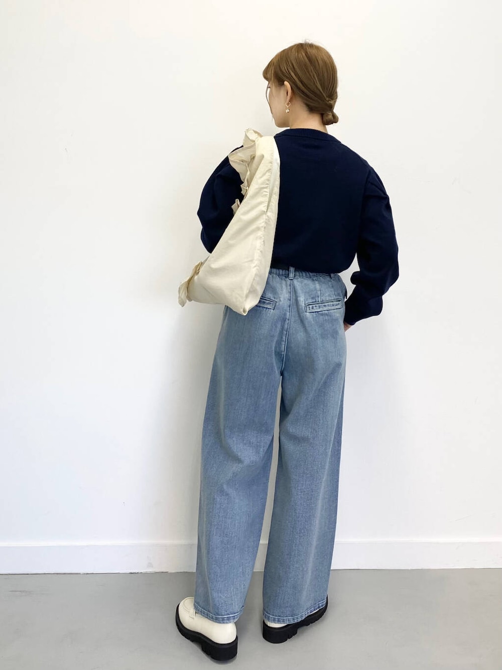 ホワイト系のローファー、ブルー系のデニムパンツ、ホワイト系のトートバッグを着用したレディースの冬コーディネートの6枚目の写真