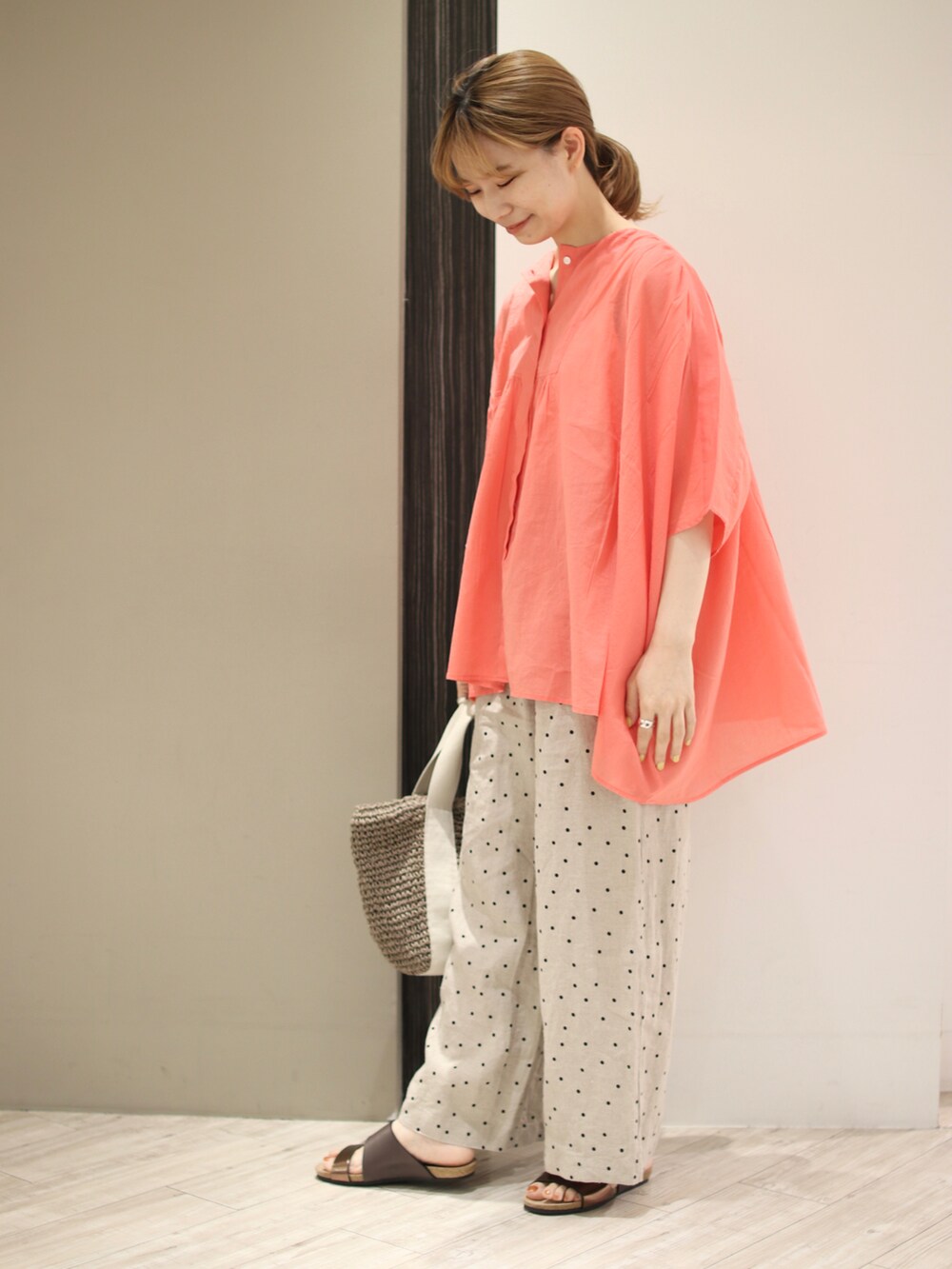 ピンク系のシャツ/ブラウス、ベージュ系のその他パンツ、グレー系のトートバッグを着用したレディースの夏コーディネートの3枚目の写真