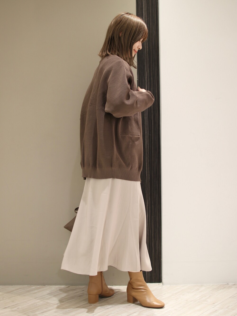 ブラウン系のカーディガン/ボレロ、ブラック系のTシャツ/カットソー、グレー系のスカートを着用したレディースの冬コーディネートの3枚目の写真