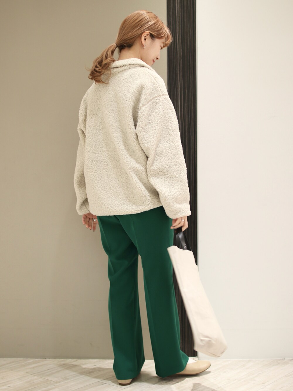 グリーン系のその他パンツ、ベージュ系のトートバッグ、ホワイト系のTシャツ/カットソーを着用したレディースの冬コーディネートの4枚目の写真