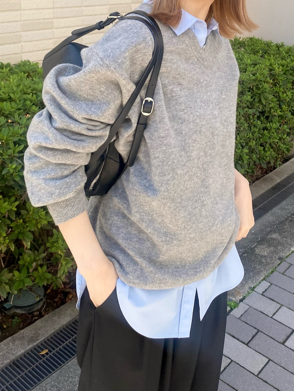 ブルー系のシャツ/ブラウス、ブラック系のボストンバッグ、グレー系のニット/セーターを着用したレディースの秋コーディネートの4枚目の写真