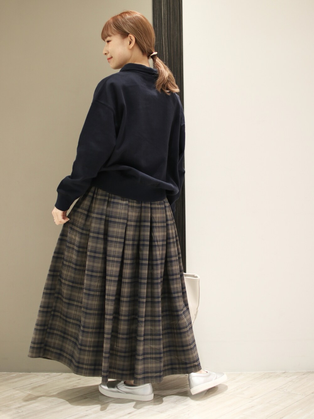 ブラウン系のスカート、ブルー系のスウェット、ベージュ系のトートバッグを着用したレディースの秋コーディネートの4枚目の写真