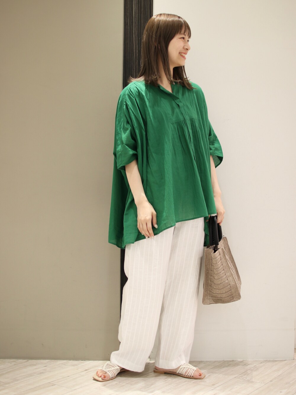 ベージュ系のトートバッグ、グリーン系のシャツ/ブラウス、ホワイト系のその他パンツを着用したレディースの夏コーディネートの2枚目の写真