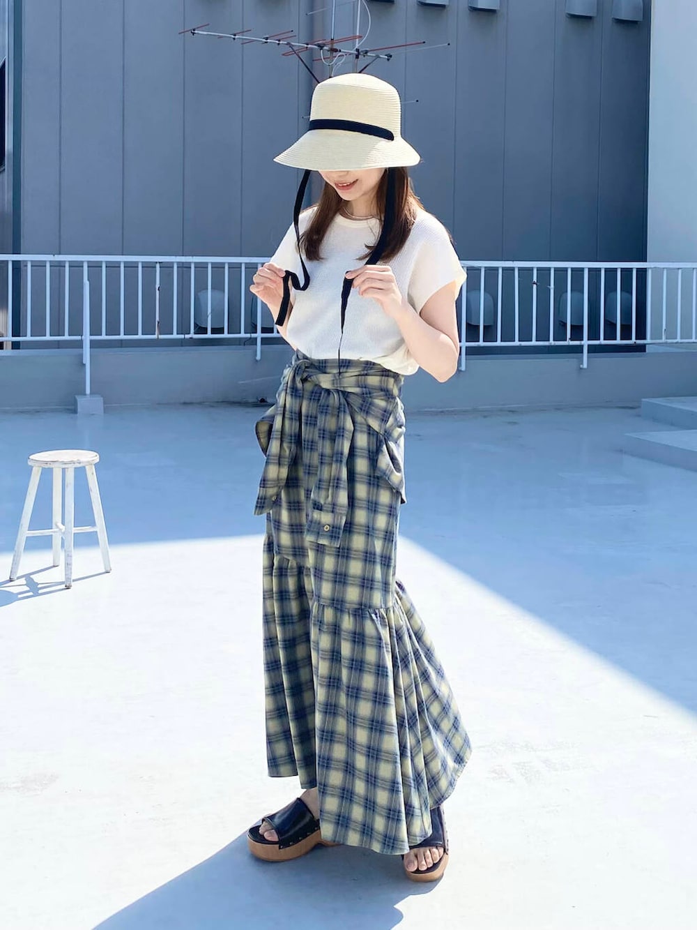 ベージュ系のスカート、ホワイト系のTシャツ/カットソー、ブラウン系のサンダルを着用したレディースの春コーディネートの4枚目の写真