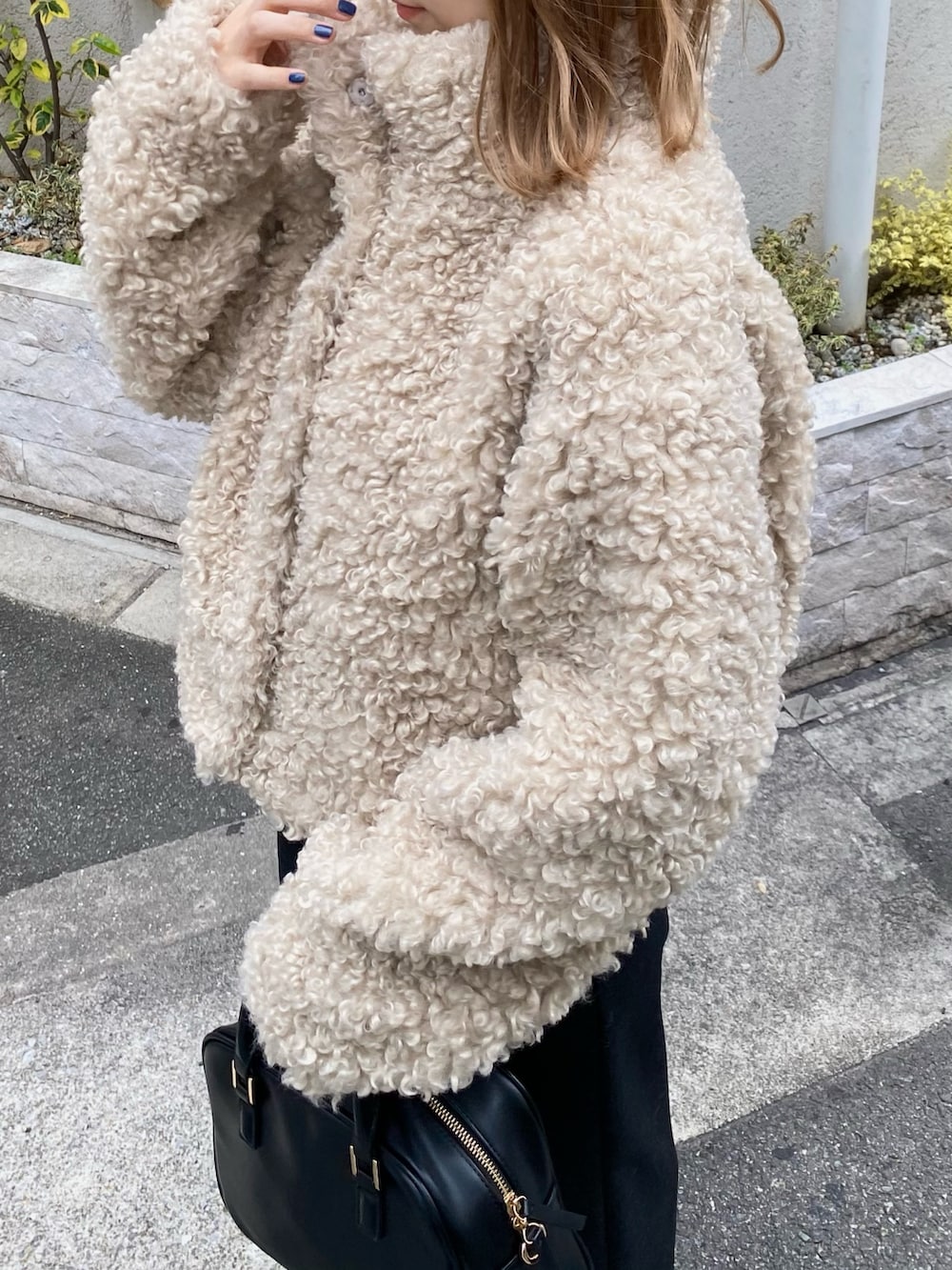 ホワイト系のその他アウター、ブラック系のスカート、ブラック系のボストンバッグを着用したレディースの冬コーディネートの2枚目の写真