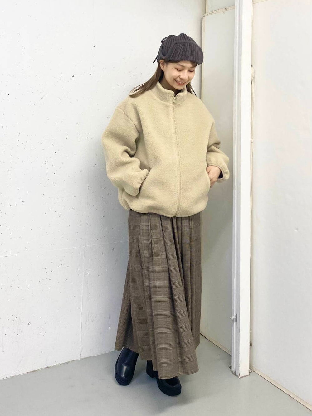 ブラック系のブーツ、その他のスカート、ホワイト系のブルゾンを着用したレディースの秋コーディネートの5枚目の写真