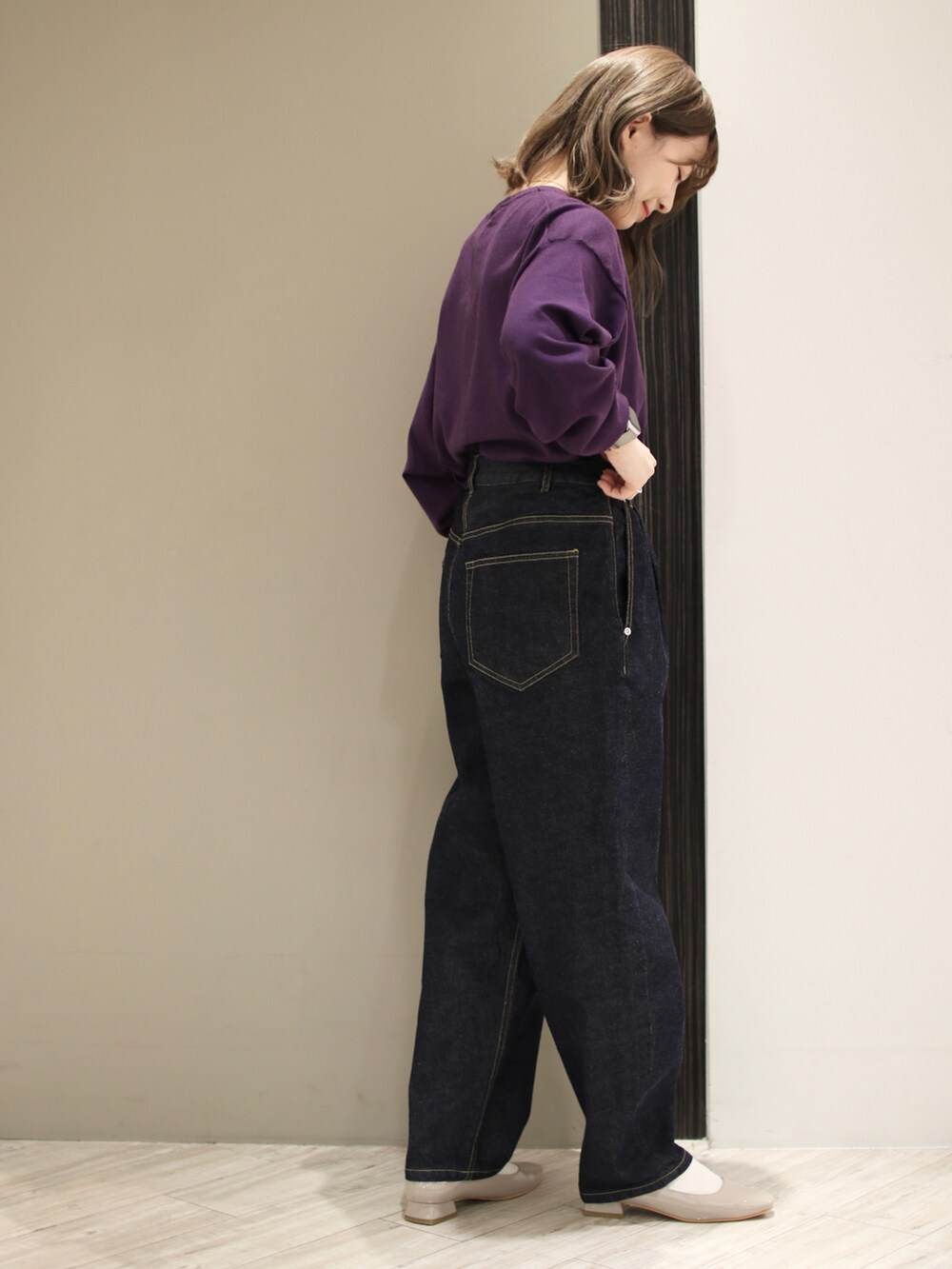 ブルー系のデニムパンツ、ブラック系のショルダーバッグ、パープル系のニット/セーターを着用したレディースの冬コーディネートの3枚目の写真