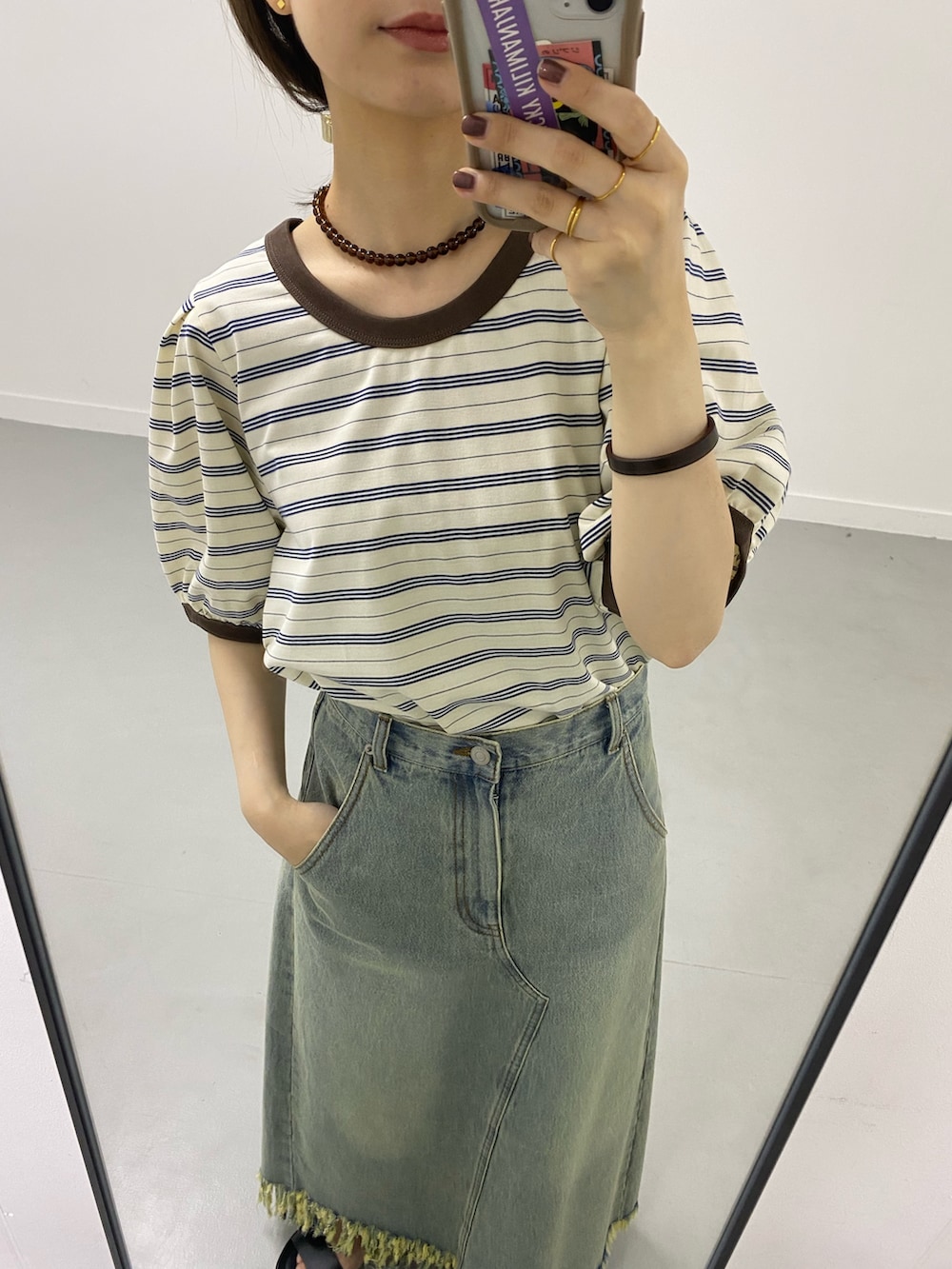 ブルー系のスカート、ホワイト系のTシャツ/カットソー、ゴールド系のリングを着用したレディースの春コーディネートの7枚目の写真