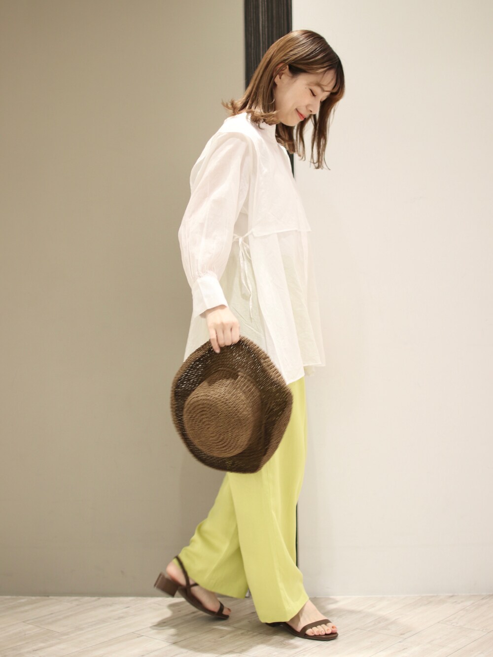 イエロー系のその他パンツ、ホワイト系のシャツ/ブラウス、ブラウン系のサンダルを着用したレディースの春コーディネートの2枚目の写真