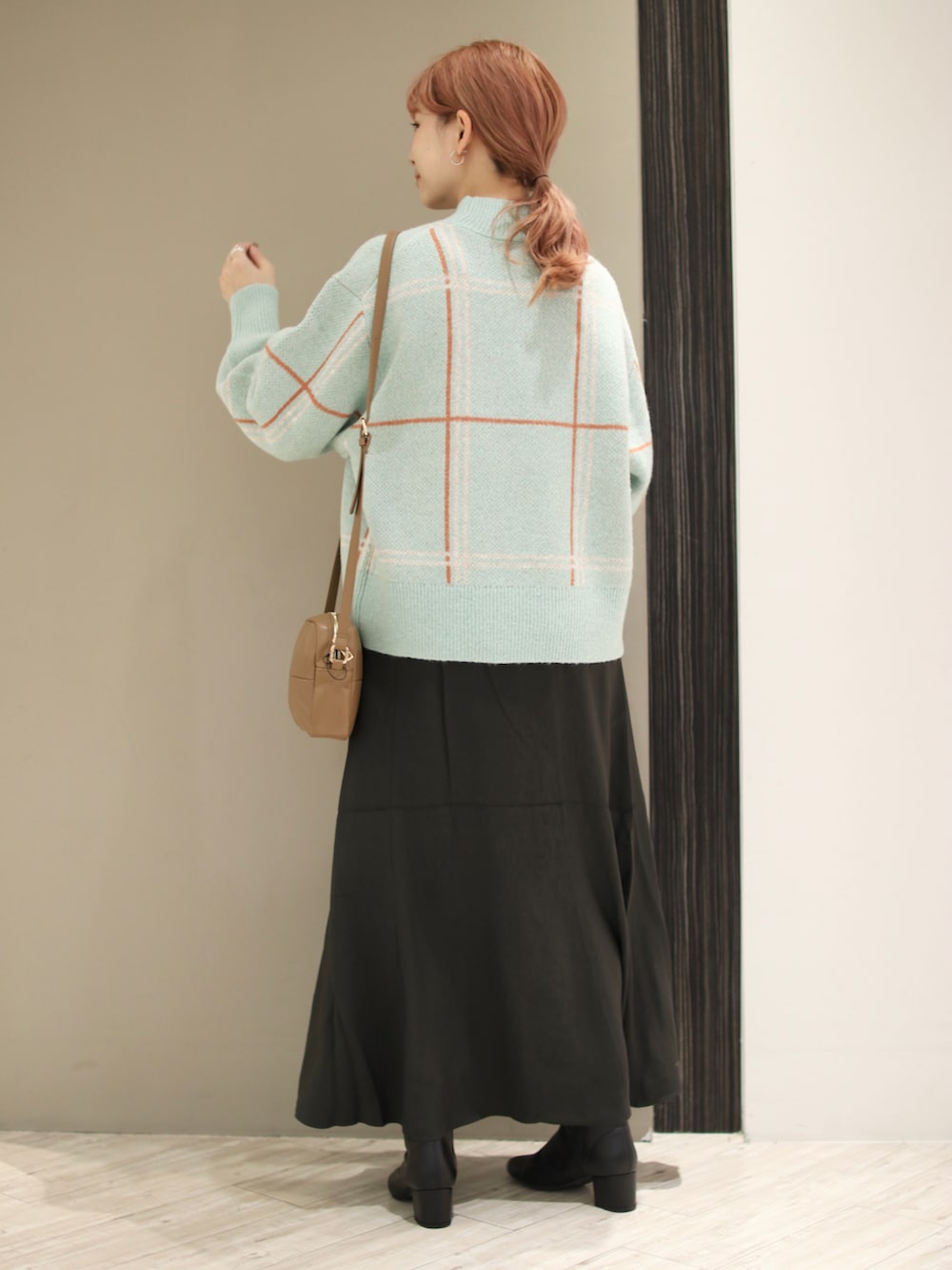 ブルー系のニット/セーター、イエロー系のショルダーバッグ、グレー系のスカートを着用したレディースの秋コーディネートの4枚目の写真