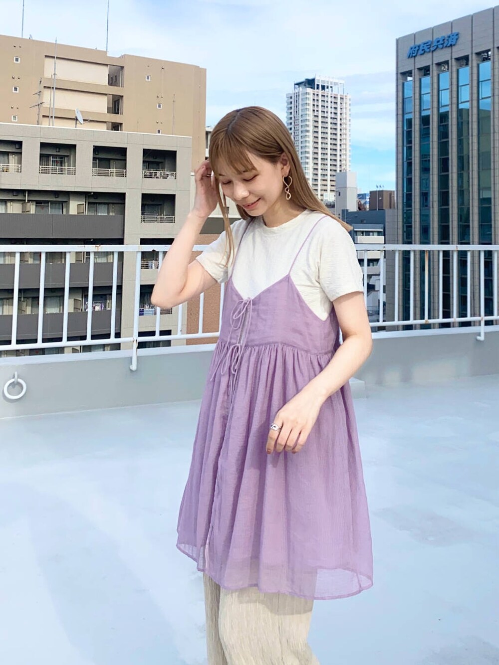 ベージュ系のその他パンツ、ホワイト系のTシャツ/カットソー、ブラック系のサンダルを着用したレディースの夏コーディネートの2枚目の写真