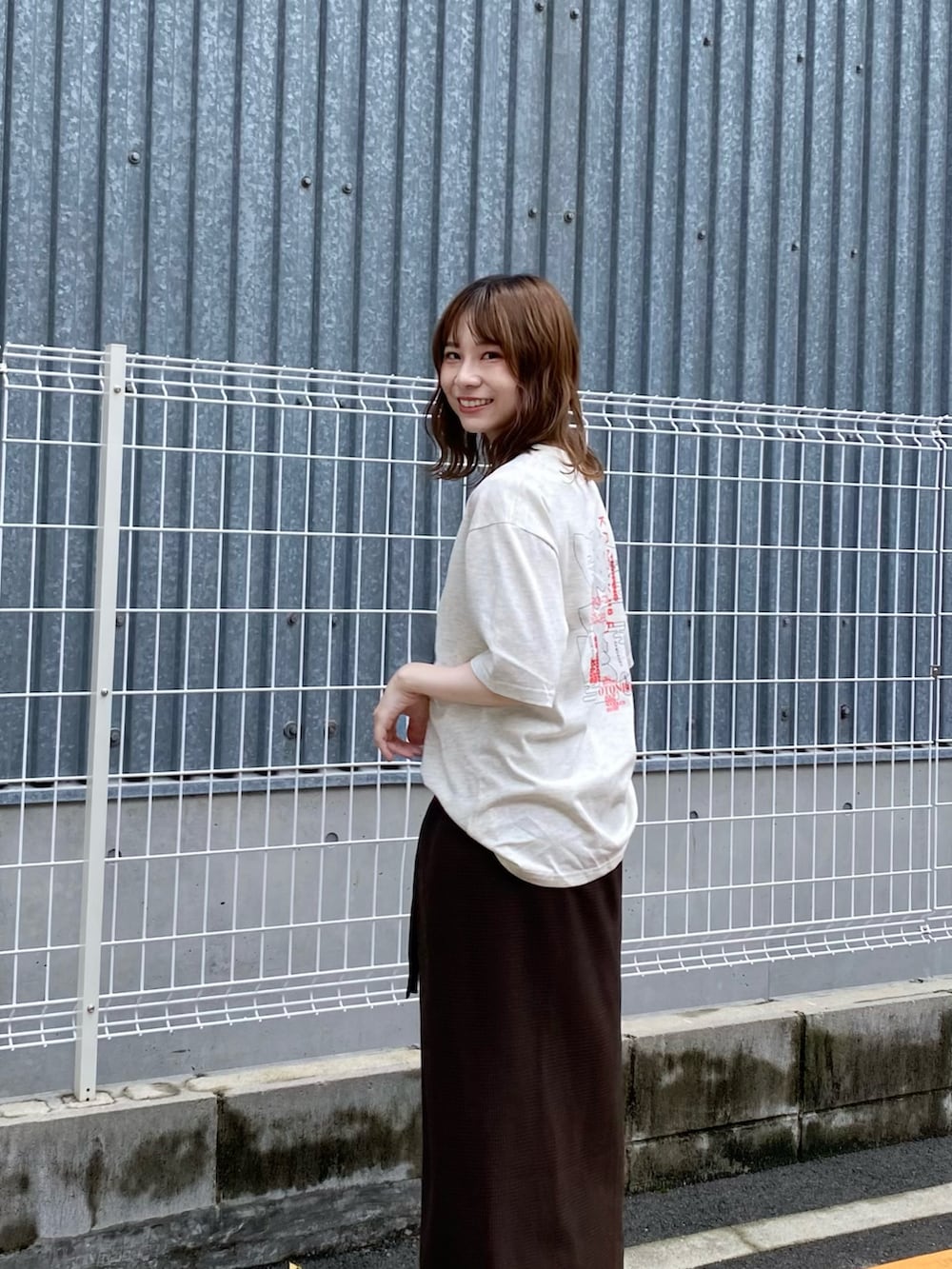 ブラウン系のスカート、ホワイト系のTシャツ/カットソーを着用したレディースの夏コーディネートの6枚目の写真