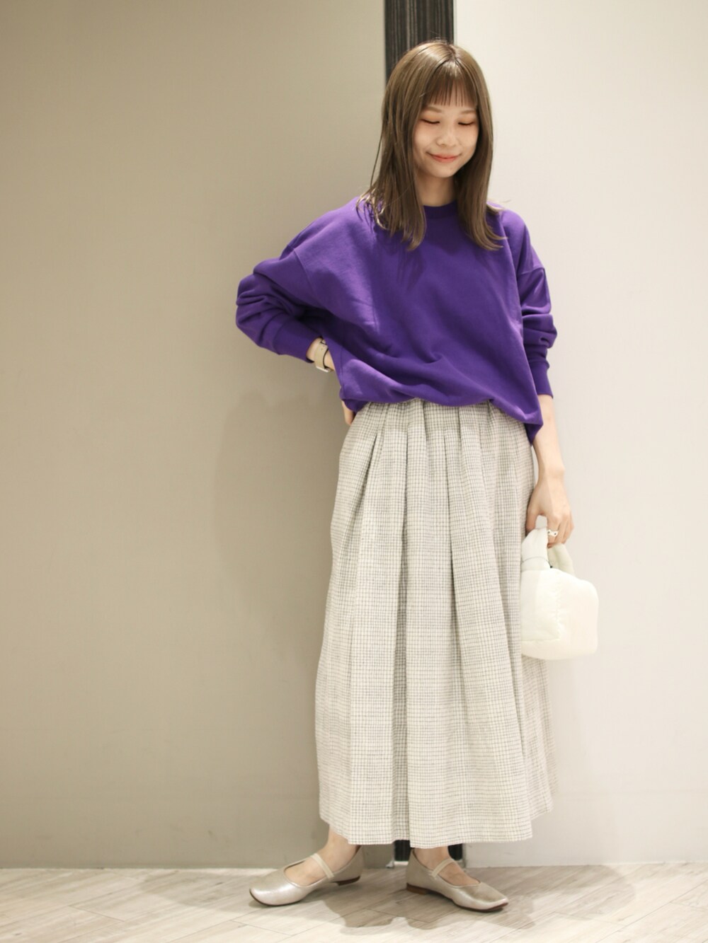 ホワイト系のスカート、パープル系のスウェット、ゴールド系のその他シューズを着用したレディースの秋コーディネートの2枚目の写真