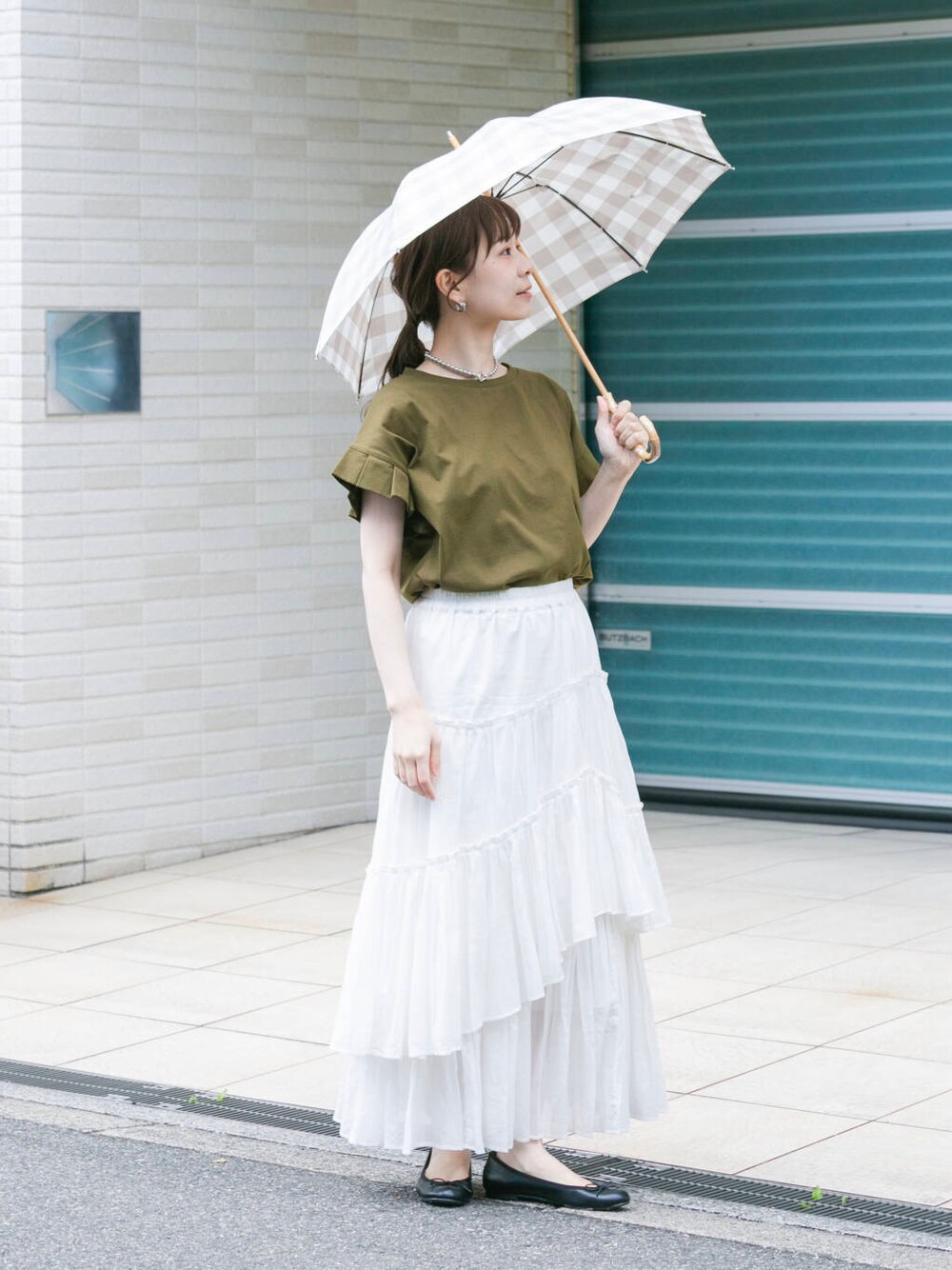 グリーン系のTシャツ/カットソー、ホワイト系のスカート、シルバー系のネックレスを着用したレディースの春コーディネートの4枚目の写真