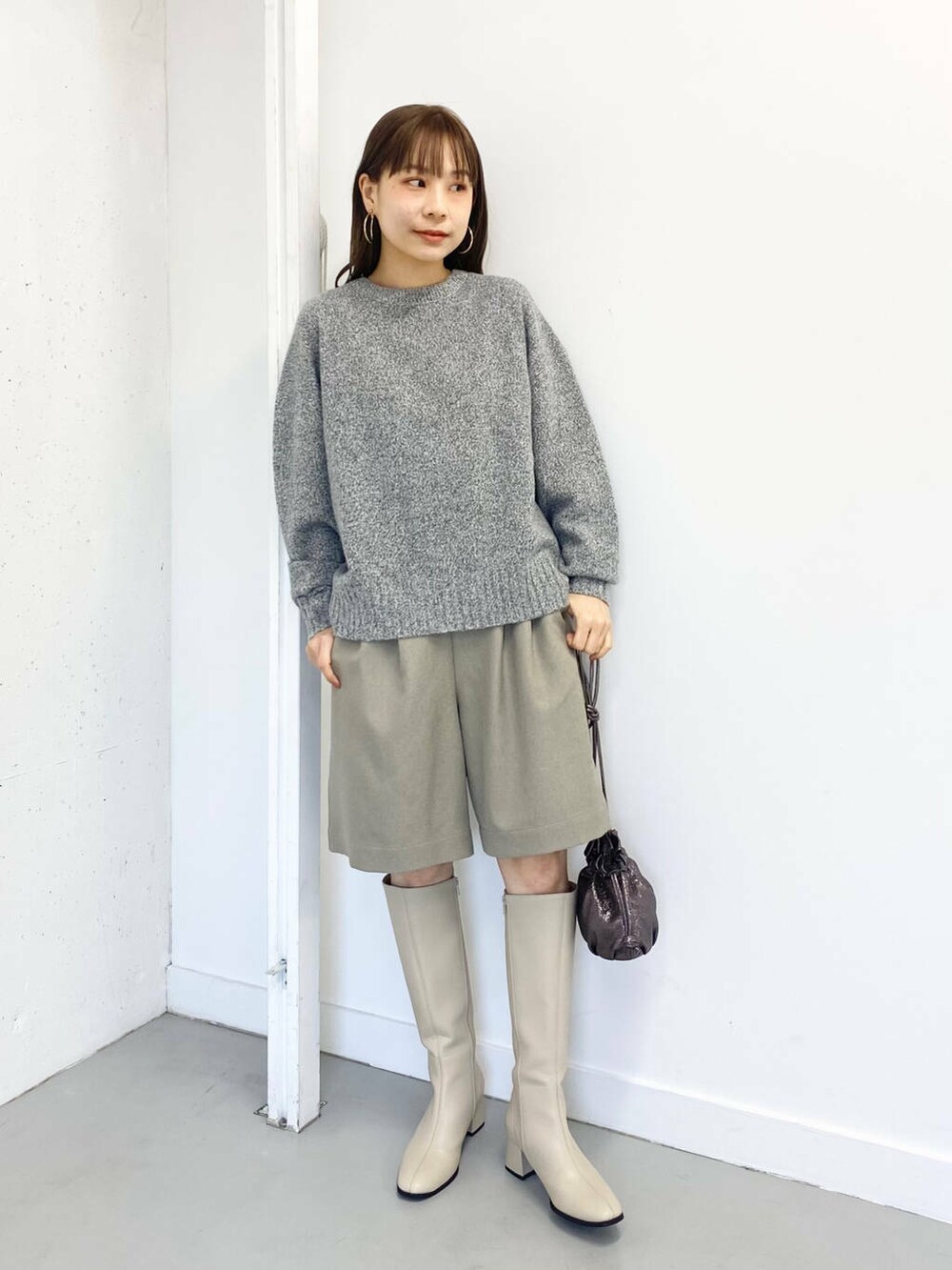 グレー系のニット/セーター、ベージュ系のその他パンツ、ホワイト系のブーツを着用したレディースの冬コーディネートの4枚目の写真