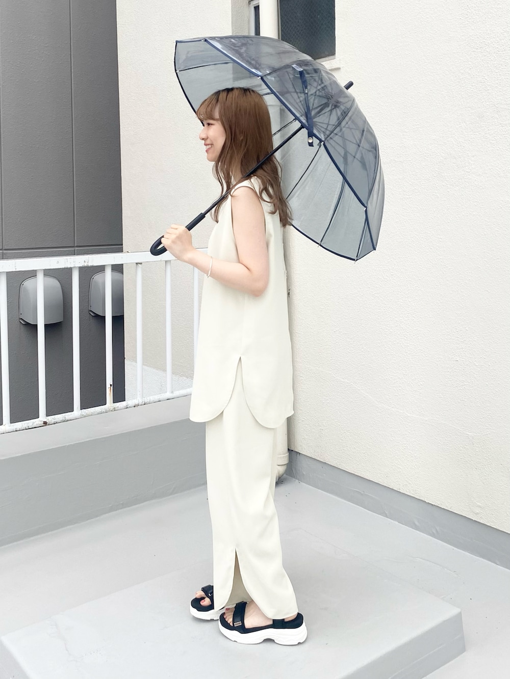 ブラック系のサンダル、ホワイト系のセットアップ、シルバー系のネックレスを着用したレディースの夏コーディネートの4枚目の写真