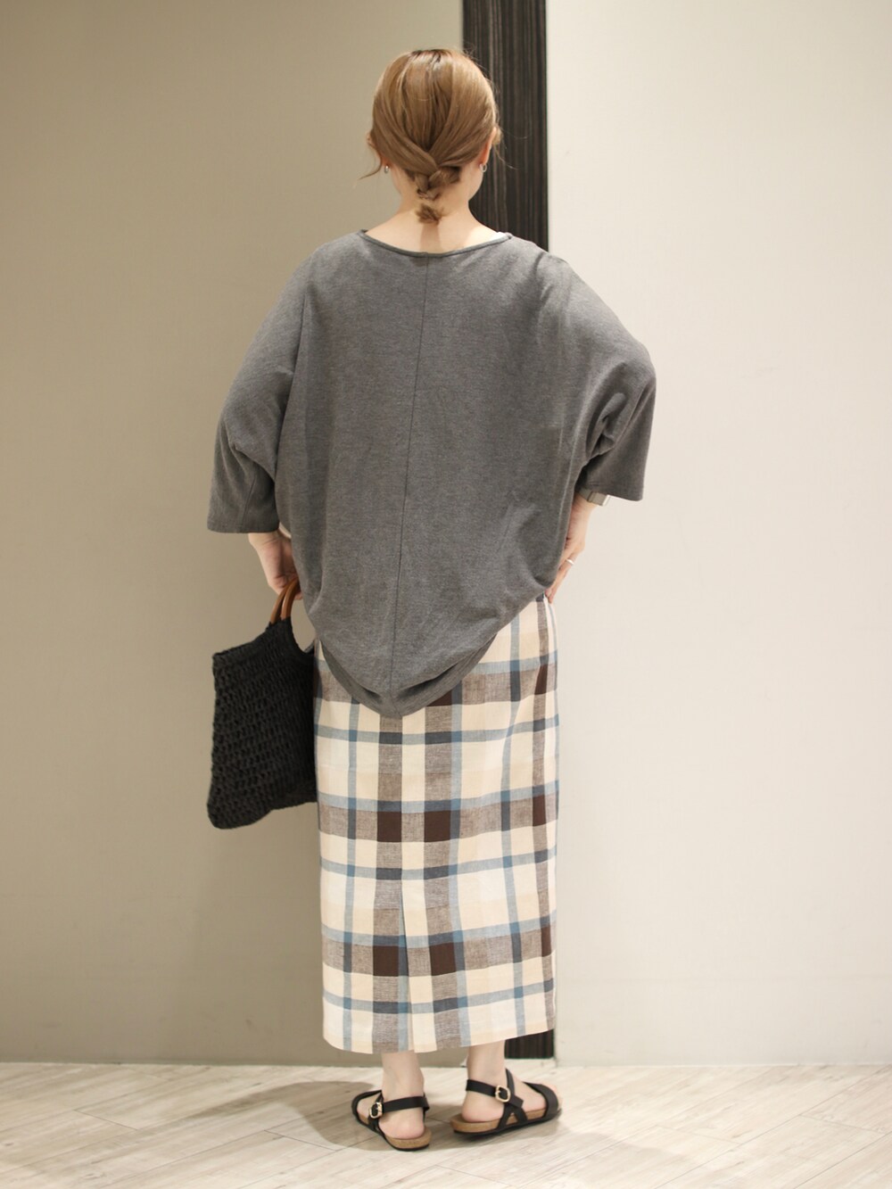 グレー系のTシャツ/カットソー、ブルー系のスカート、ブラック系のトートバッグを着用したレディースの夏コーディネートの3枚目の写真