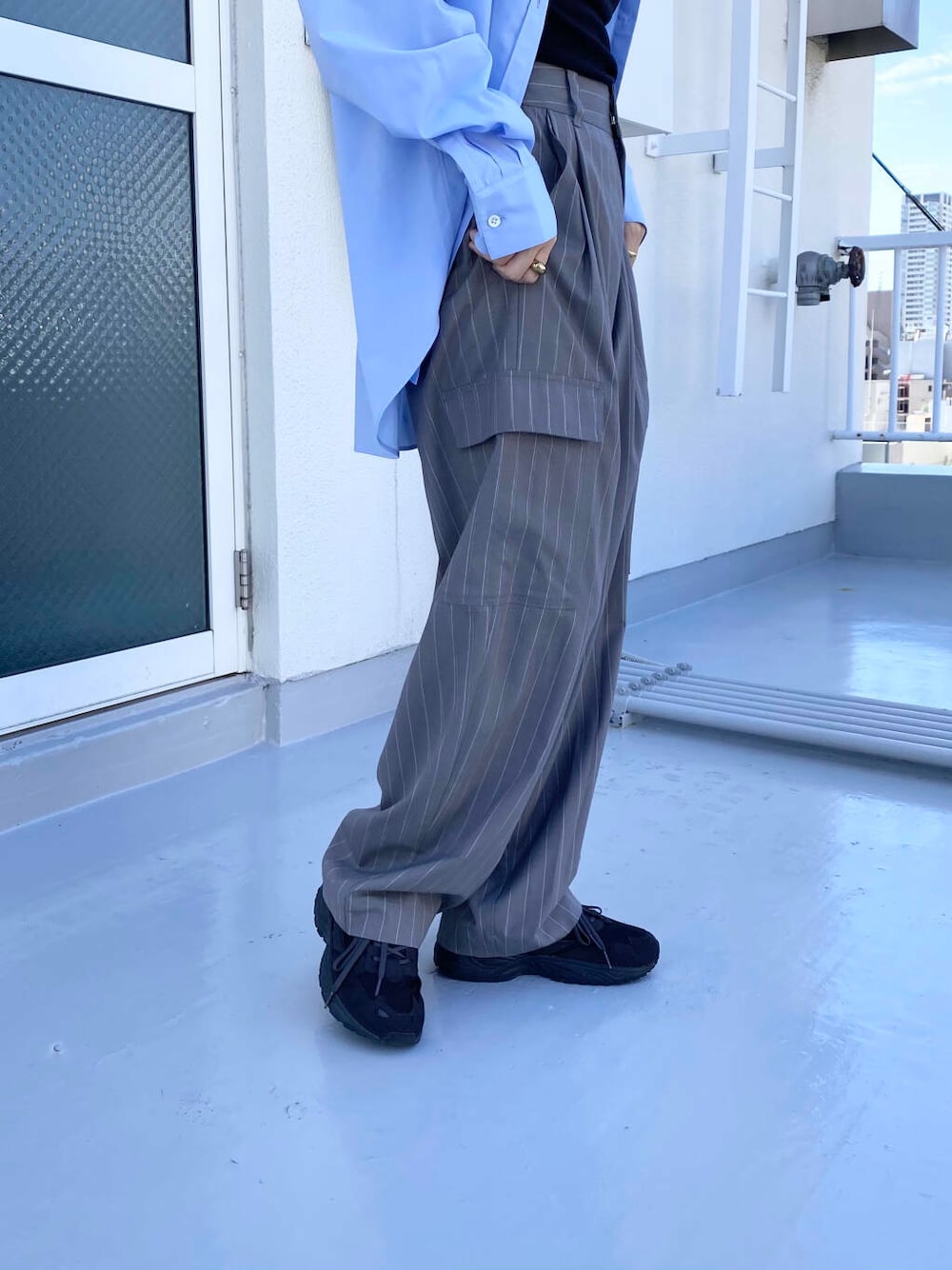 ブラック系のキャミソール、グレー系のスニーカー、ブルー系のシャツ/ブラウスを着用したレディースの秋コーディネートの2枚目の写真