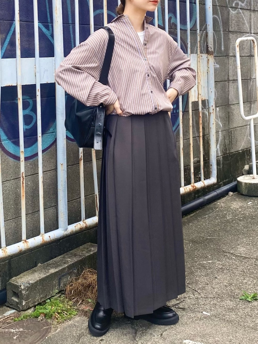 グレー系のスカート、ブラウン系のシャツ/ブラウス、ブラック系のローファーを着用したレディースの秋コーディネートの4枚目の写真
