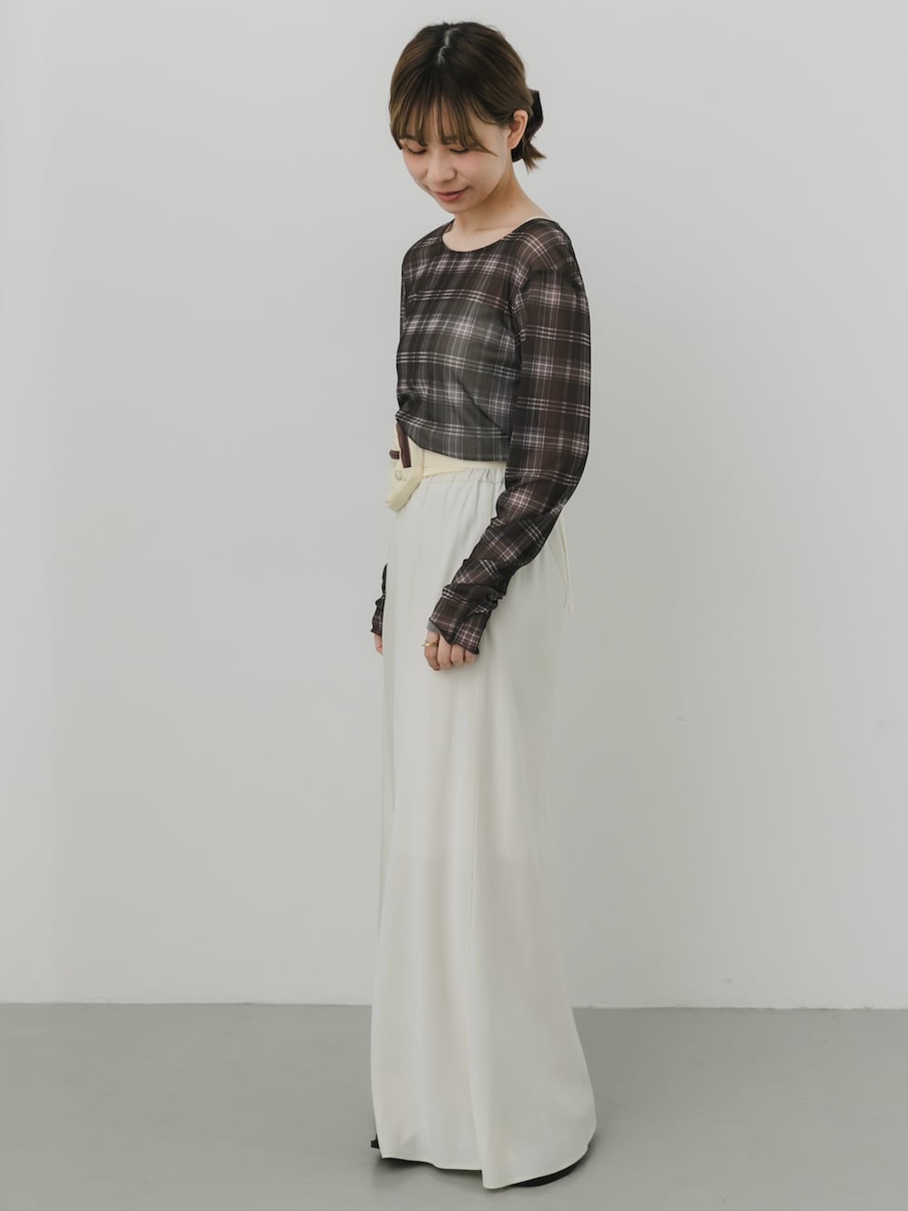 イエロー系のボディバッグ/ウエストポーチ、ホワイト系のスカート、グリーン系のTシャツ/カットソーを着用したレディースの秋コーディネートの3枚目の写真