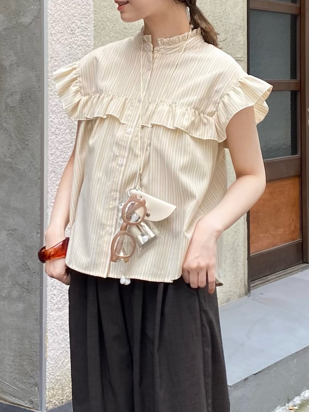 ベージュ系のシャツ/ブラウス、グレー系のその他パンツ、ブラウン系のサンダルを着用したレディースの夏コーディネートの2枚目の写真