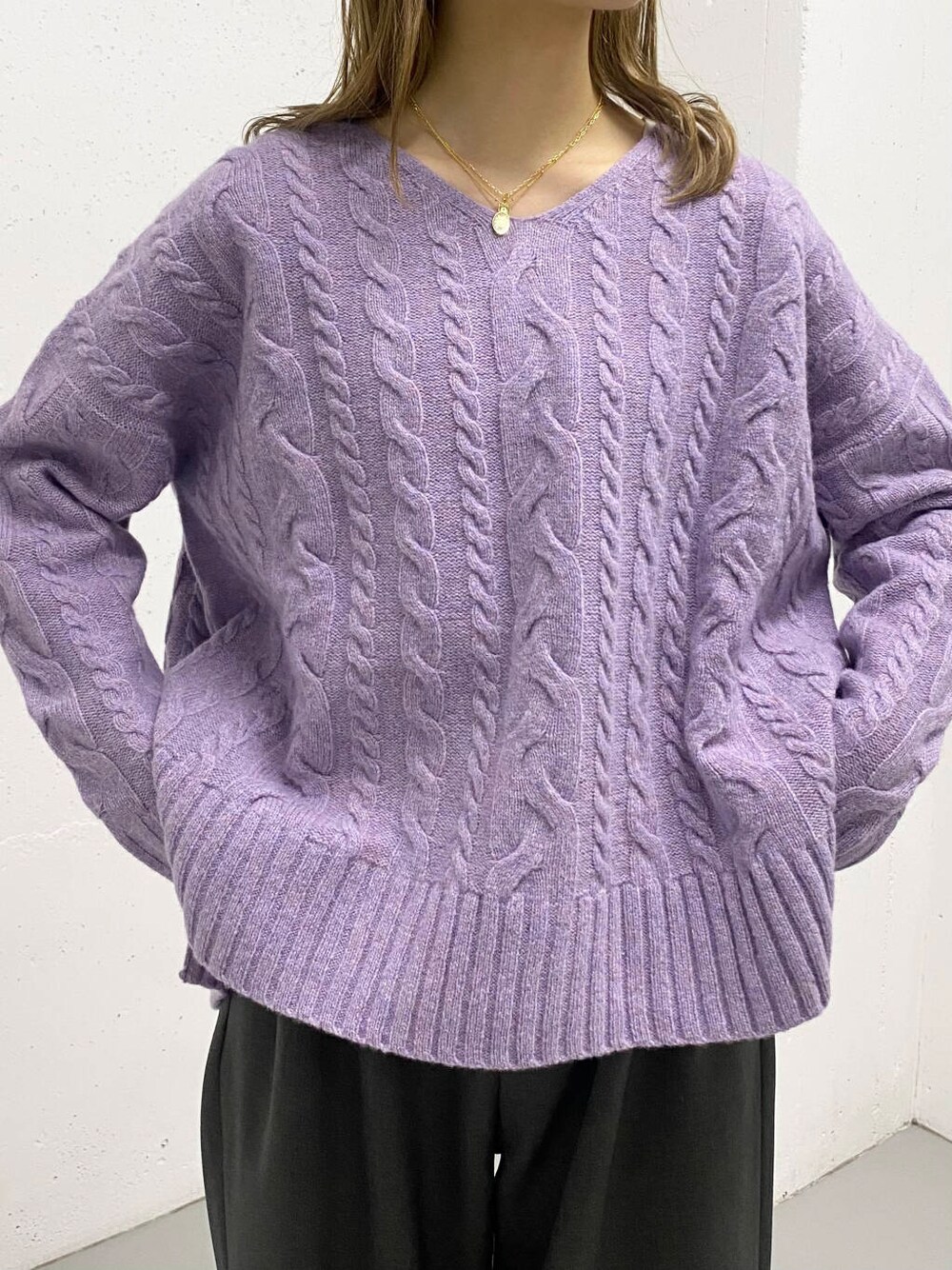 パープル系のニット/セーター、グレー系のその他パンツ、ブラック系のブーツを着用したレディースの秋コーディネートの5枚目の写真