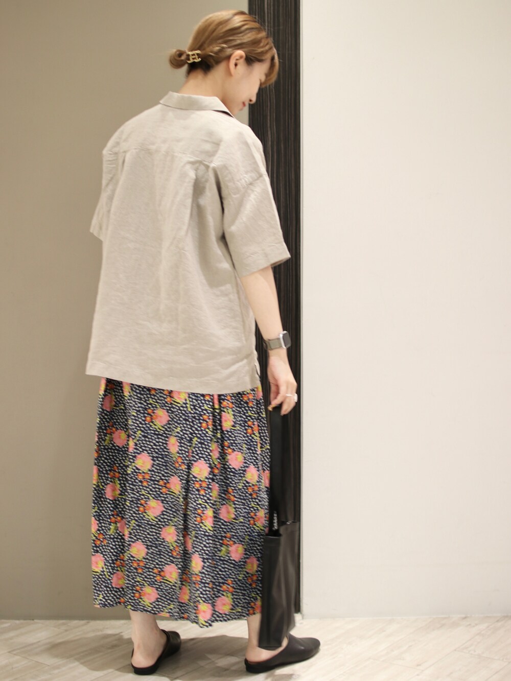 ベージュ系のTシャツ/カットソー、ブルー系のスカート、ブラック系のトートバッグを着用したレディースの夏コーディネートの5枚目の写真