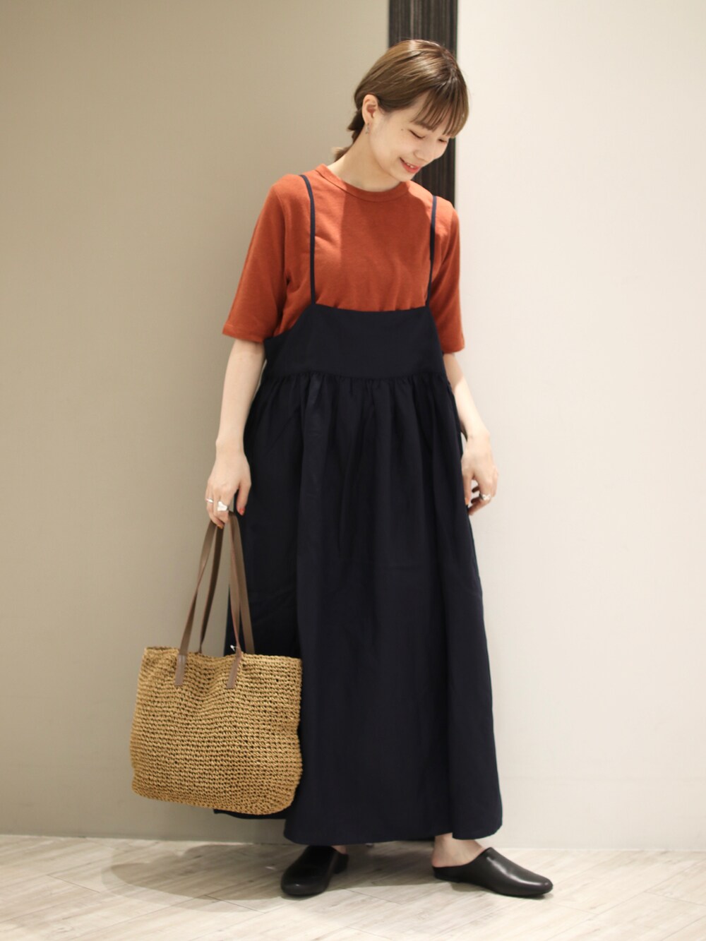 ブラウン系のTシャツ/カットソー、ブラック系のワンピース、ベージュ系のトートバッグを着用したレディースの夏コーディネートの2枚目の写真