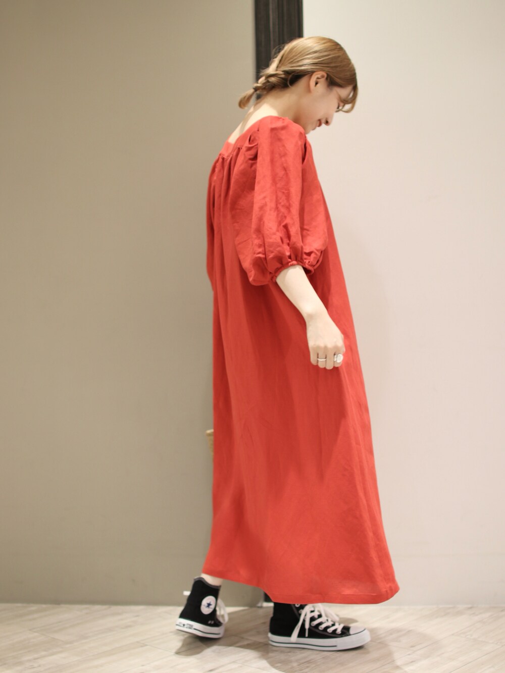 グリーン系のトートバッグ、レッド系のワンピース、ブラック系のスニーカーを着用したレディースの夏コーディネートの3枚目の写真