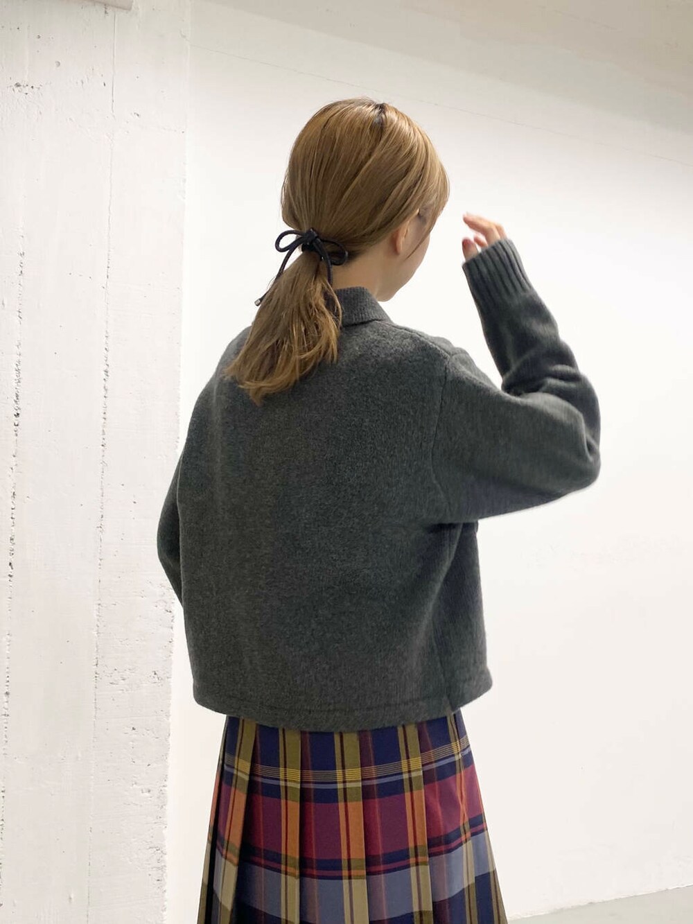 ブラック系のボストンバッグ、ブラック系のブーツ、ブルー系のスカートを着用したレディースの秋コーディネートの2枚目の写真