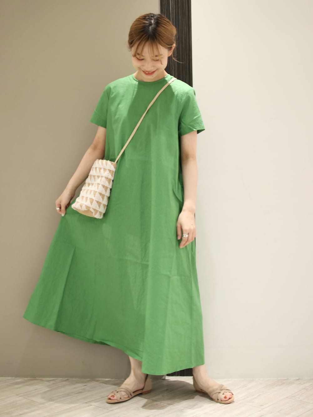 グリーン系のワンピース、ホワイト系のショルダーバッグ、ベージュ系のサンダルを着用したレディースの夏コーディネートの2枚目の写真