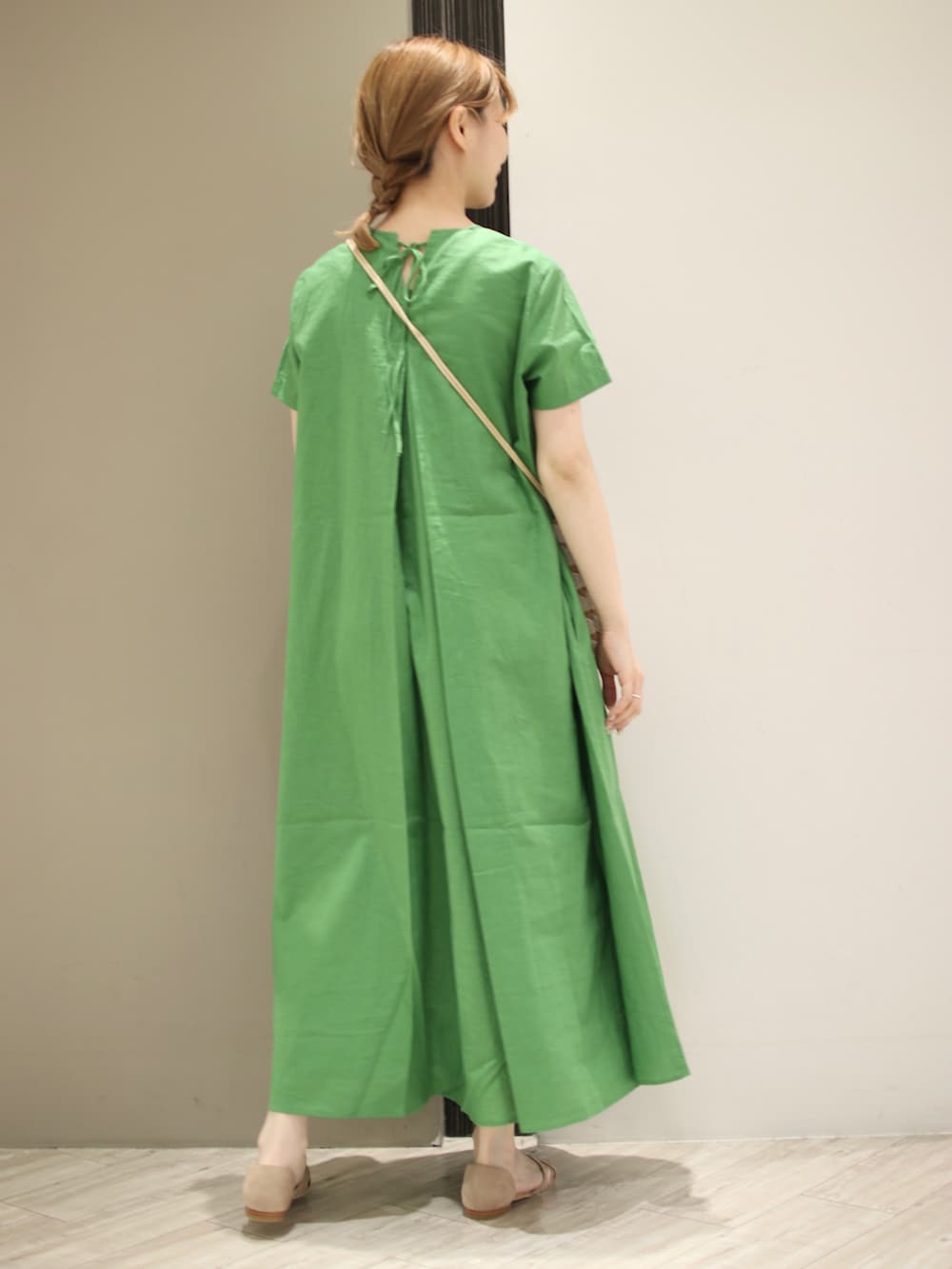 グリーン系のワンピース、ホワイト系のショルダーバッグ、ベージュ系のサンダルを着用したレディースの夏コーディネートの3枚目の写真