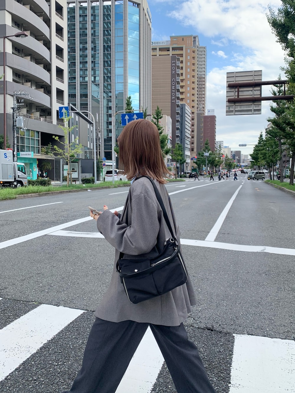 ブラック系のショルダーバッグ、グレー系のその他アウター、ブルー系のシャツ/ブラウスを着用したレディースの秋コーディネートの6枚目の写真