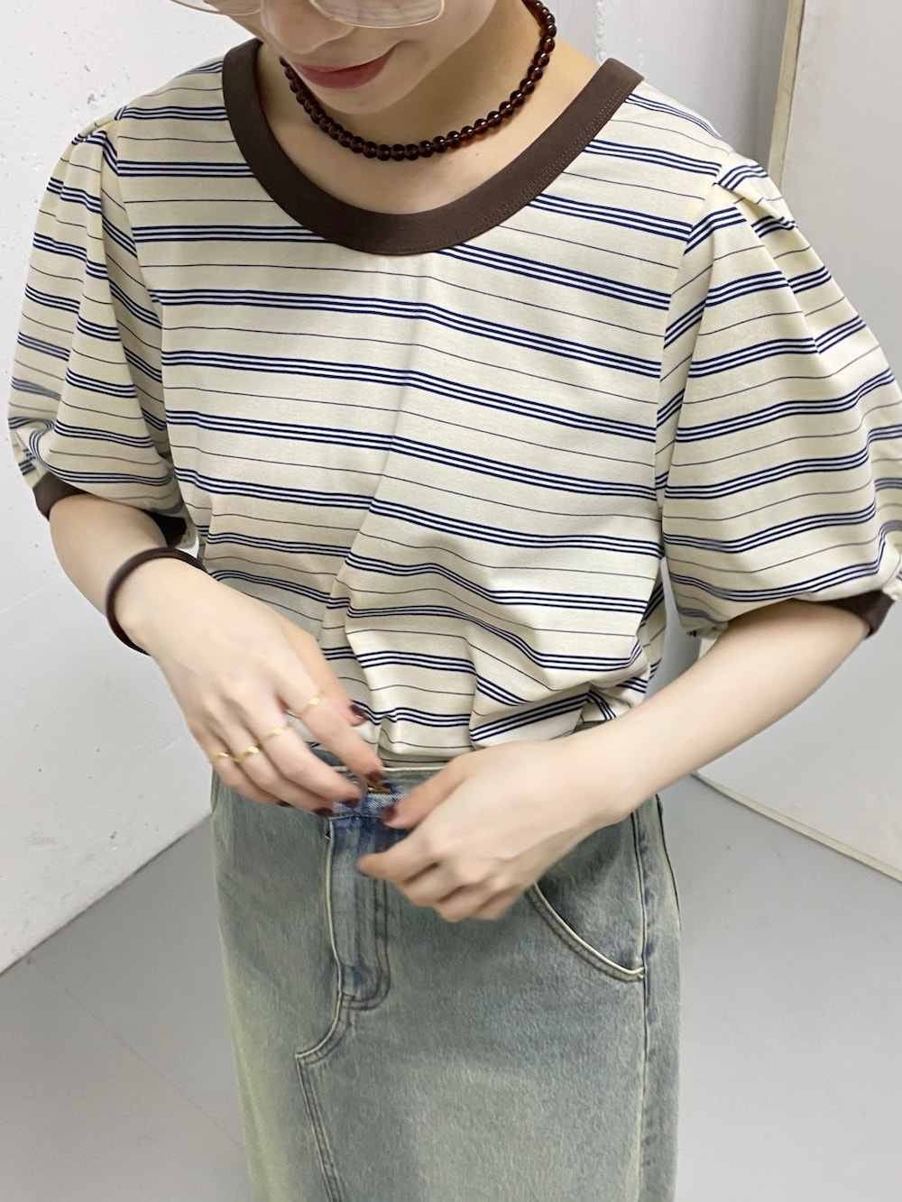 ブルー系のスカート、ホワイト系のTシャツ/カットソー、ゴールド系のリングを着用したレディースの春コーディネートの5枚目の写真