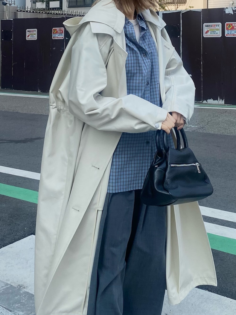 ブルー系のシャツ/ブラウス、ブラック系のローファー、ベージュ系のトレンチコートを着用したレディースの冬コーディネートの2枚目の写真